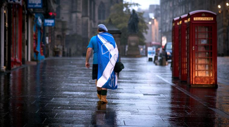 Un sostenitore dell'indipendenza scozzese cammina lungo una deserta via di Edimburgo dopo la diffusione dei risultati del referendum del 2014